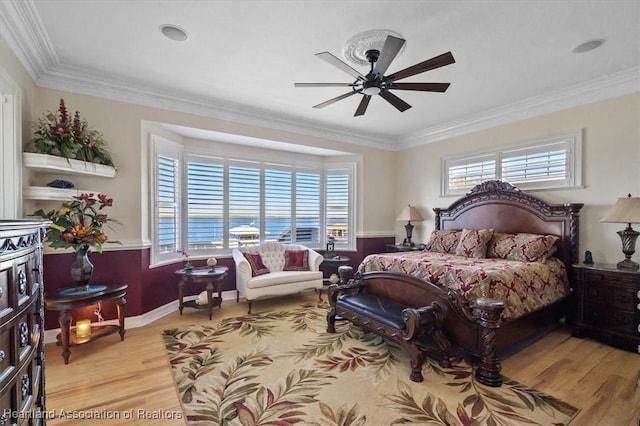 bedroom with ceiling fan, light hardwood / wood-style floors, and ornamental molding