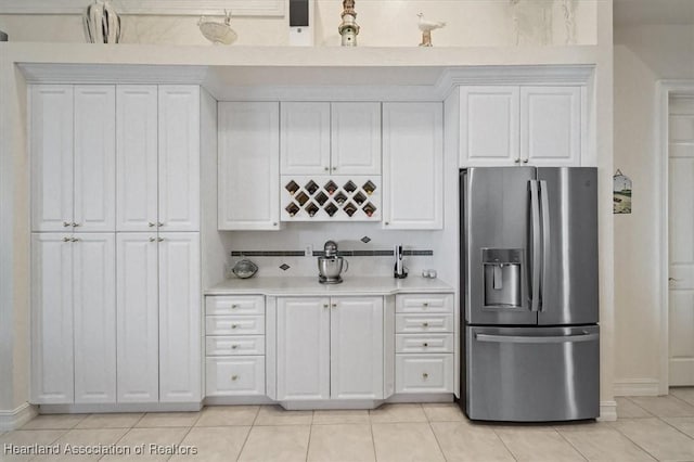 kitchen featuring white cabinetry, stainless steel fridge with ice dispenser, and light tile patterned floors