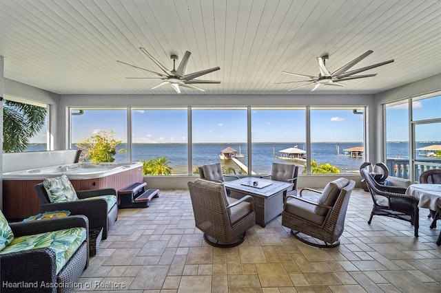 sunroom featuring a wealth of natural light, a water view, wooden ceiling, and ceiling fan