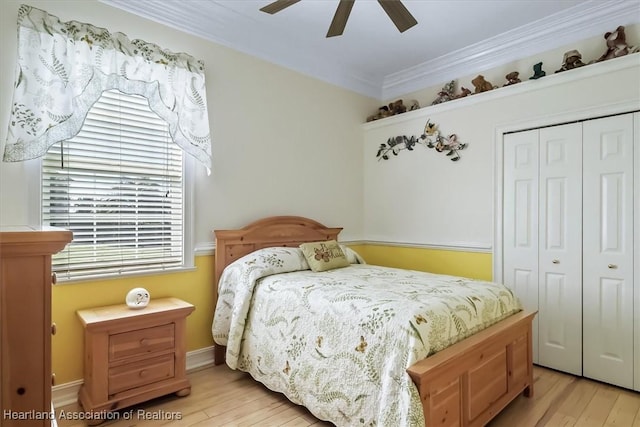 bedroom featuring ceiling fan, light wood-type flooring, crown molding, and a closet