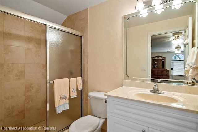 bathroom with ceiling fan, a shower with door, vanity, and toilet