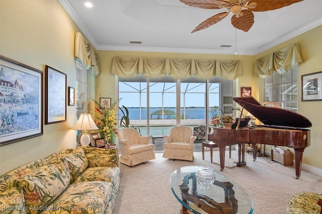 living area with carpet flooring, ceiling fan, a water view, and ornamental molding