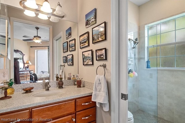 bathroom with an enclosed shower, vanity, toilet, and plenty of natural light