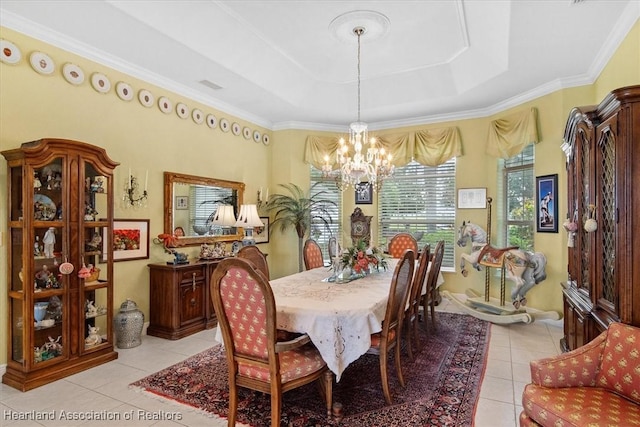 tiled dining area with a tray ceiling, an inviting chandelier, and ornamental molding