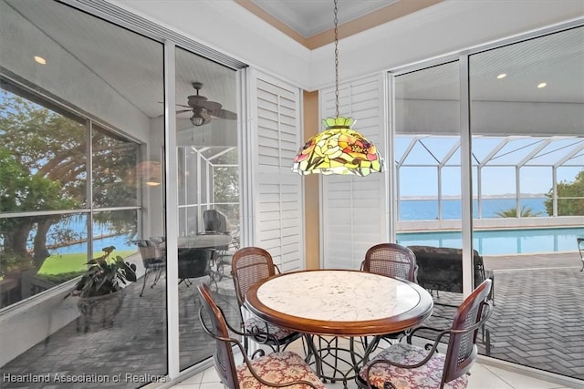 sunroom / solarium with ceiling fan and a water view