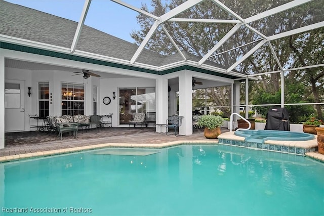 view of swimming pool featuring ceiling fan, a lanai, an in ground hot tub, a grill, and a patio area