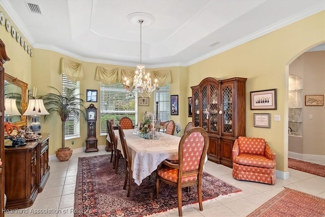 dining space with a tray ceiling, a notable chandelier, ornamental molding, and light tile patterned flooring