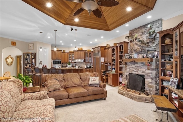 living room featuring a fireplace, ceiling fan, wood ceiling, and light carpet