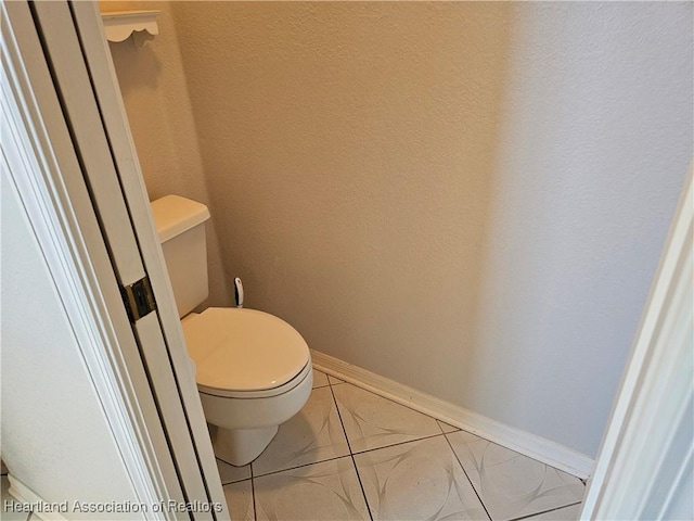 bathroom with toilet and tile patterned flooring