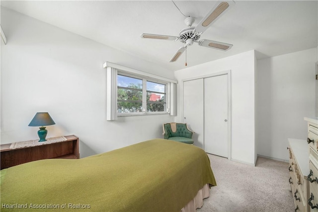 bedroom featuring ceiling fan, light carpet, and a closet