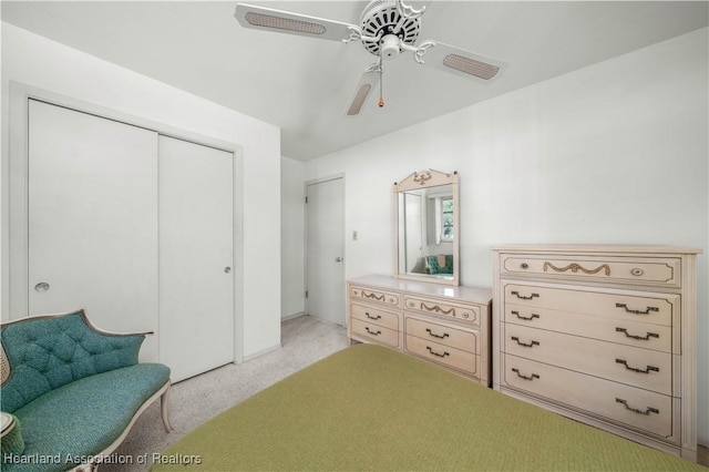 carpeted bedroom featuring ceiling fan and a closet