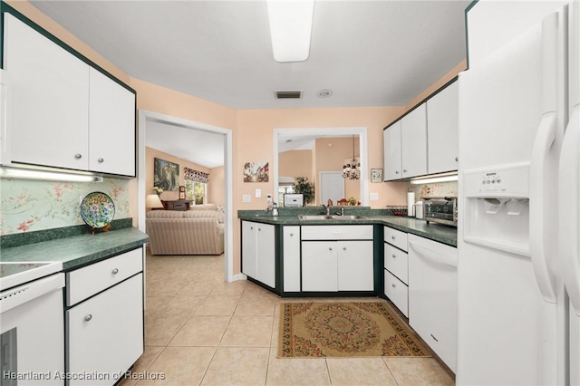 kitchen featuring visible vents, a sink, white refrigerator with ice dispenser, and dark countertops