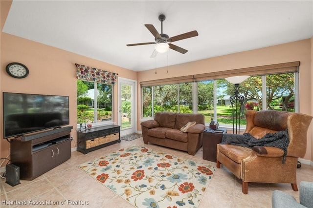 living room featuring a ceiling fan, baseboards, and light tile patterned flooring