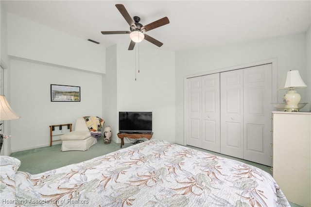carpeted bedroom featuring visible vents, a ceiling fan, lofted ceiling, and a closet