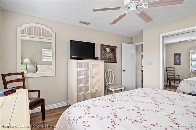 bedroom with ceiling fan, hardwood / wood-style floors, and a textured ceiling