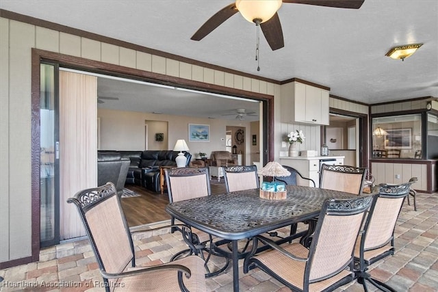 dining room featuring ceiling fan, a textured ceiling, and ornamental molding