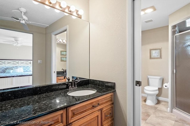 bathroom featuring vanity, toilet, walk in shower, and tile patterned flooring