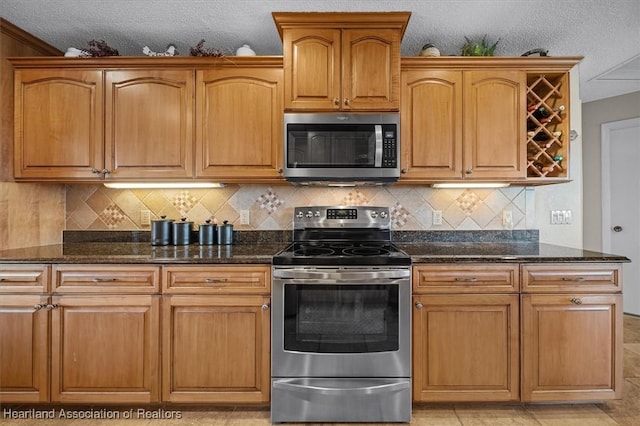 kitchen featuring tasteful backsplash, dark stone counters, and stainless steel appliances