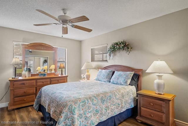 bedroom with ceiling fan, dark hardwood / wood-style floors, and a textured ceiling