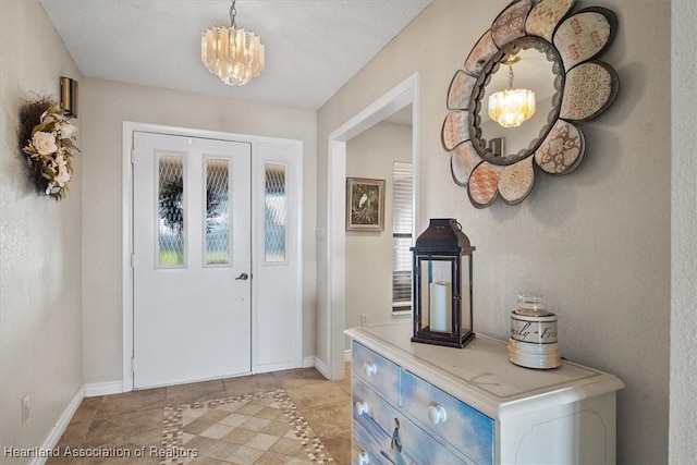 doorway to outside with a textured ceiling, a chandelier, and light tile patterned floors