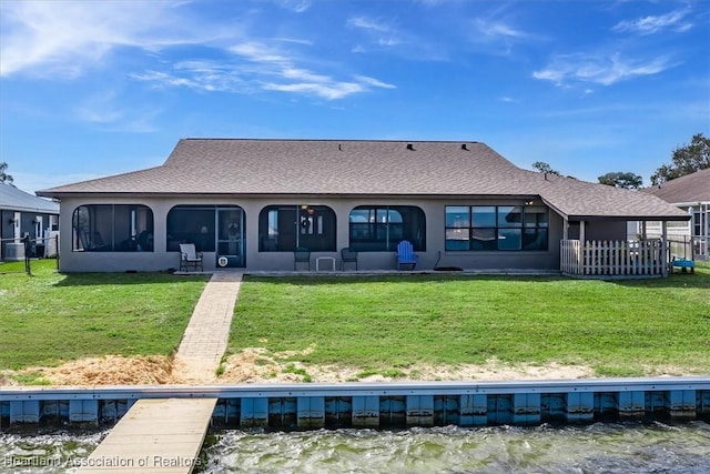 back of house featuring a lawn and a water view