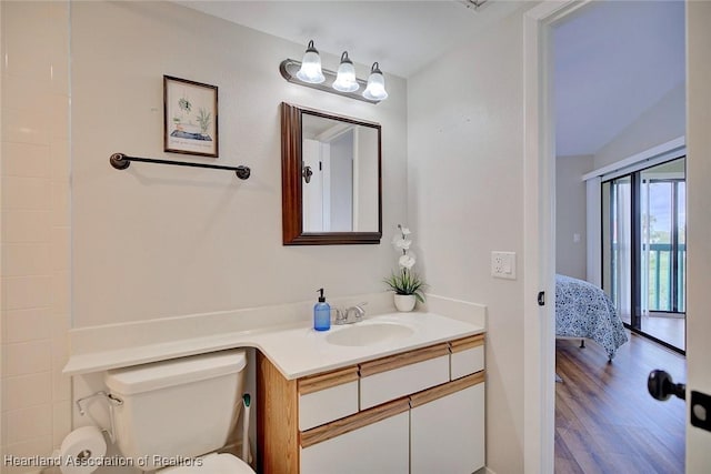 bathroom with vanity, toilet, wood-type flooring, and lofted ceiling