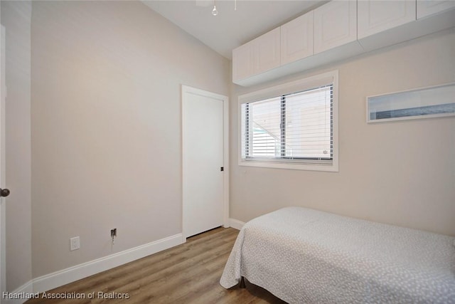 bedroom featuring lofted ceiling and light wood-type flooring