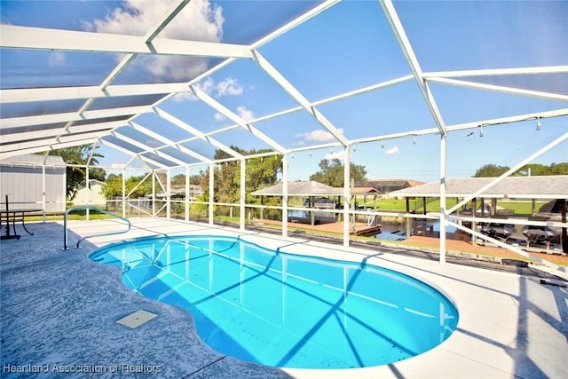 view of pool with glass enclosure and a patio