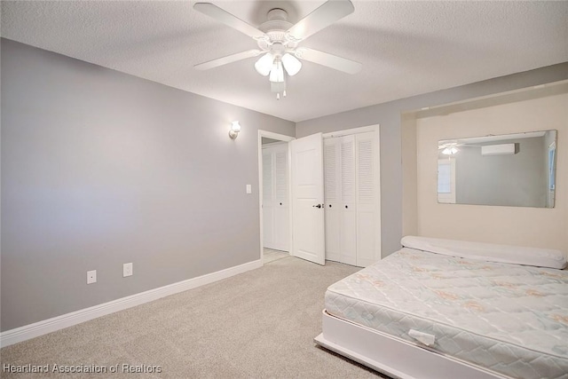 carpeted bedroom featuring ceiling fan, a closet, and a textured ceiling