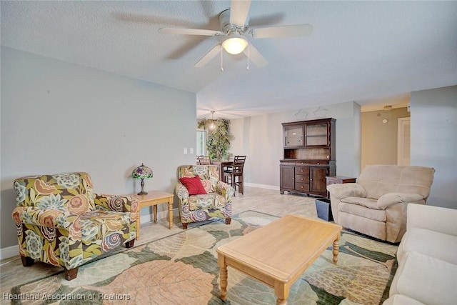 living room featuring a textured ceiling and ceiling fan