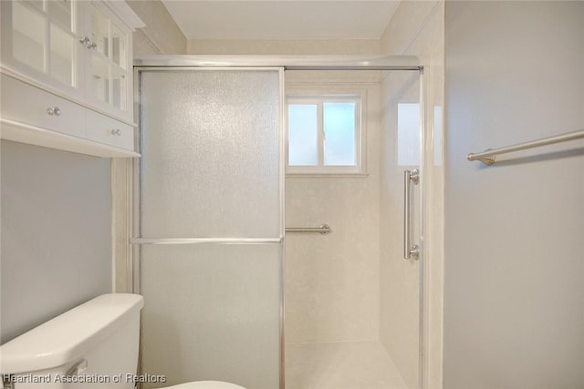 bathroom featuring walk in shower and toilet