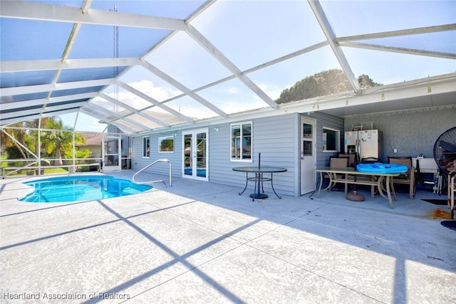 view of swimming pool with glass enclosure and a patio