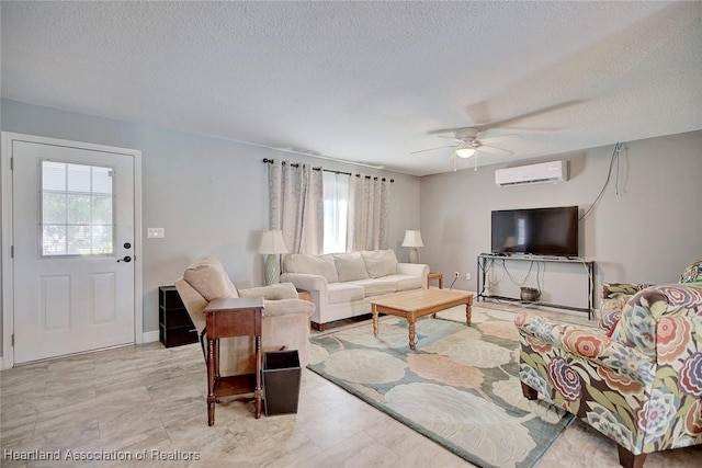 living room with a wall mounted air conditioner, a textured ceiling, plenty of natural light, and ceiling fan