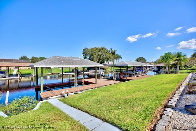 view of dock with a lawn and a water view