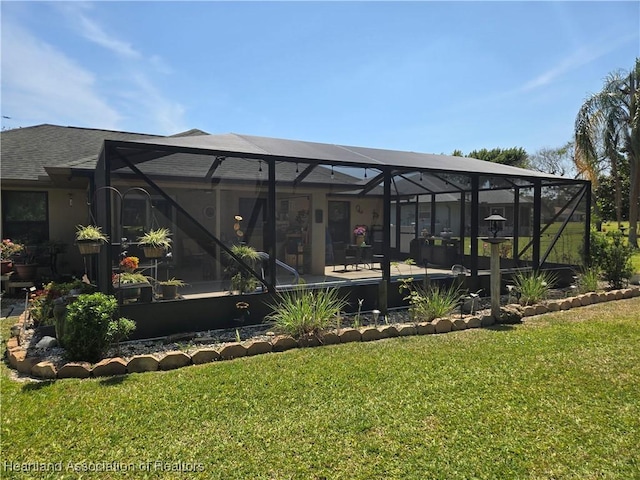 rear view of property with glass enclosure and a yard