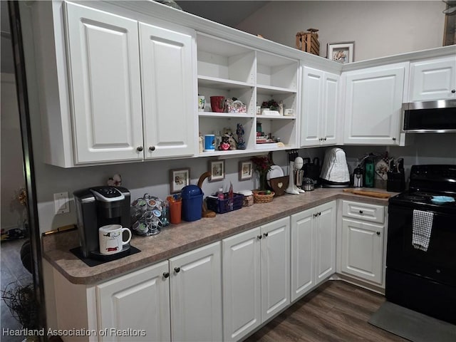 55 Lake Side Trl, Lake Placid, FL 33852 - kitchen featuring stainless steel microwave, black / electric stove, dark wood-style floors, and white cabinets