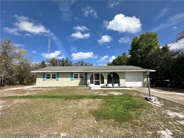 ranch-style house with a front yard, driveway, an attached garage, and stucco siding