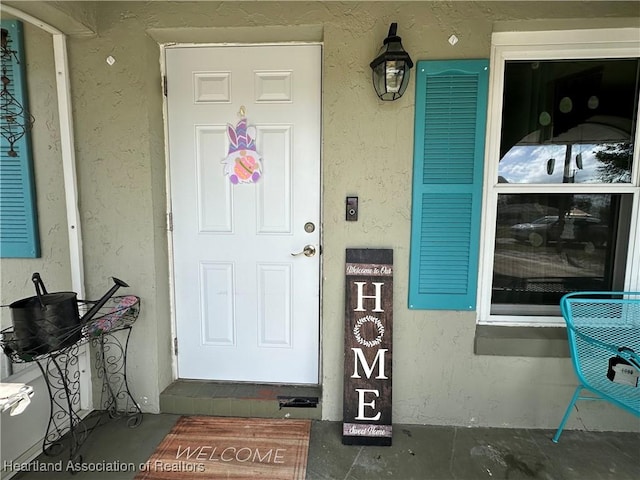 property entrance with stucco siding