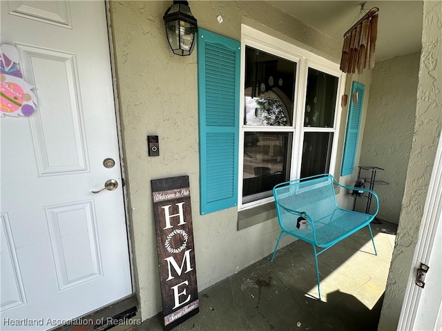 property entrance featuring a porch and stucco siding