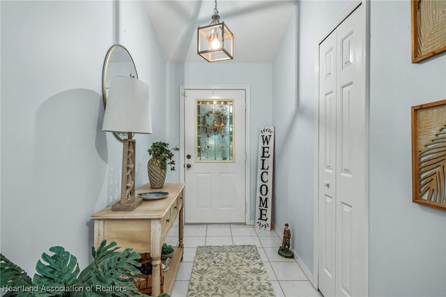 foyer entrance with lofted ceiling and light tile patterned floors