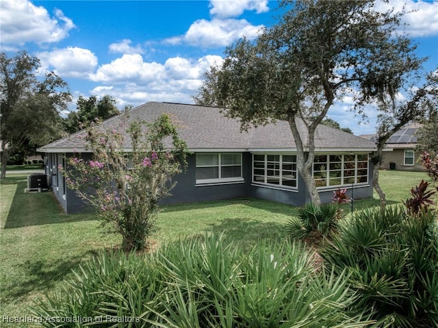 back of property featuring a lawn and cooling unit