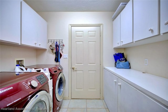 laundry room with light tile patterned floors, independent washer and dryer, and cabinets