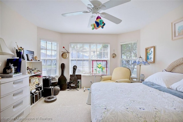 carpeted bedroom featuring ceiling fan and multiple windows