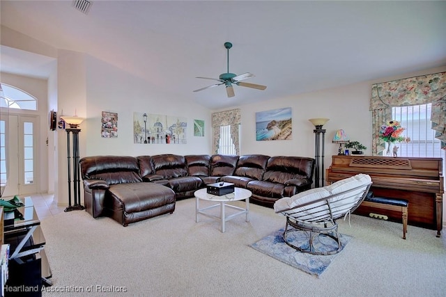 living room with ceiling fan, a wealth of natural light, light carpet, and vaulted ceiling