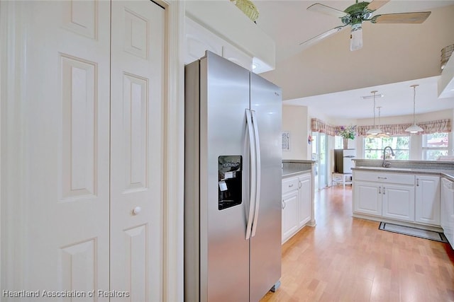 kitchen with decorative light fixtures, ceiling fan, light hardwood / wood-style floors, white cabinetry, and stainless steel fridge with ice dispenser