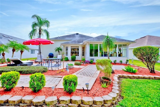 rear view of house featuring a patio area and a yard