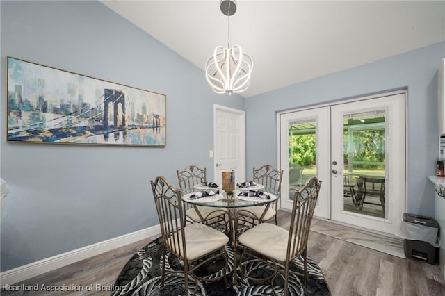 dining area featuring vaulted ceiling, wood finished floors, french doors, baseboards, and a notable chandelier