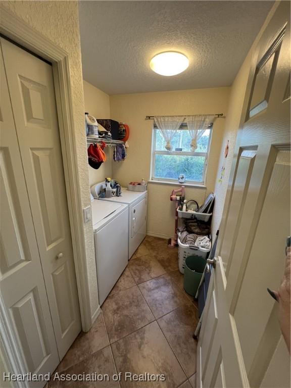 laundry room featuring light tile patterned flooring, independent washer and dryer, and a textured ceiling