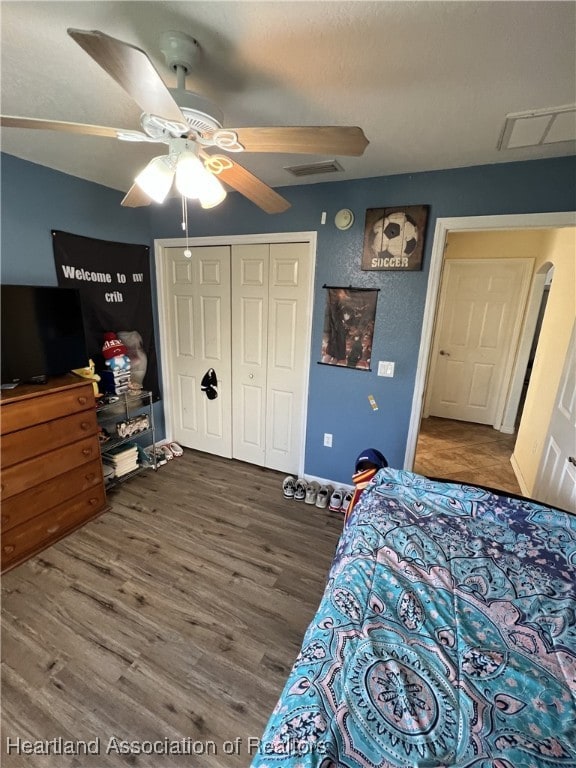 bedroom with hardwood / wood-style flooring, ceiling fan, and a closet