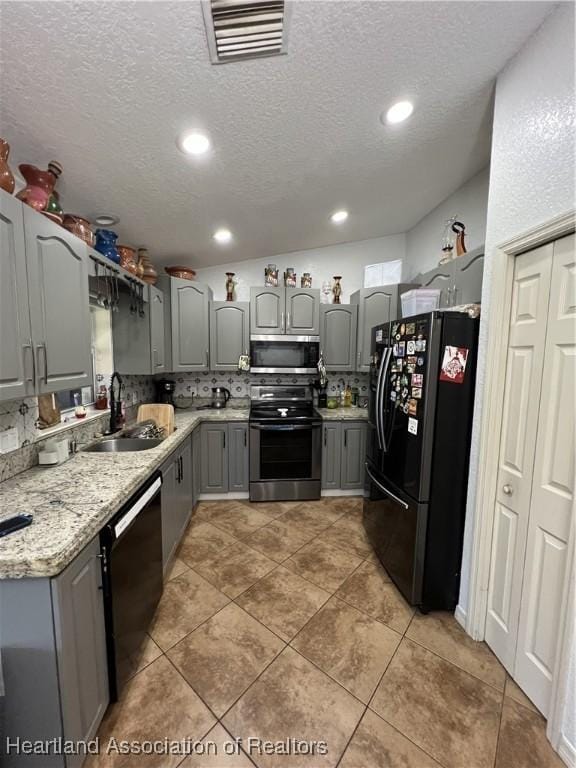 kitchen with sink, gray cabinetry, decorative backsplash, black appliances, and tile patterned floors